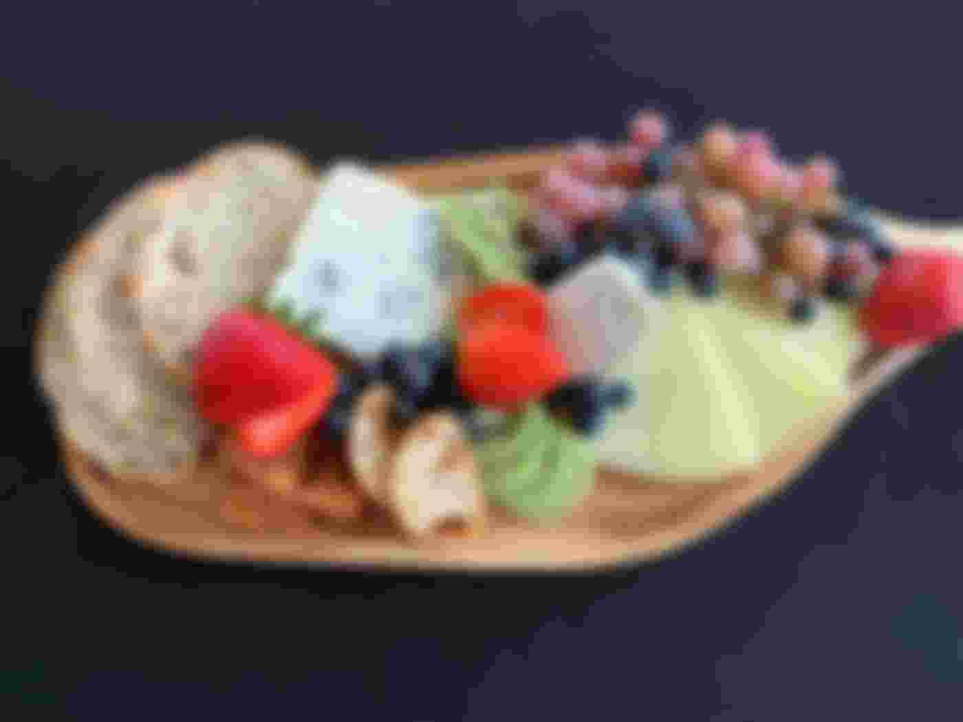 cheese bread and fruit plate on wooden cutting board
