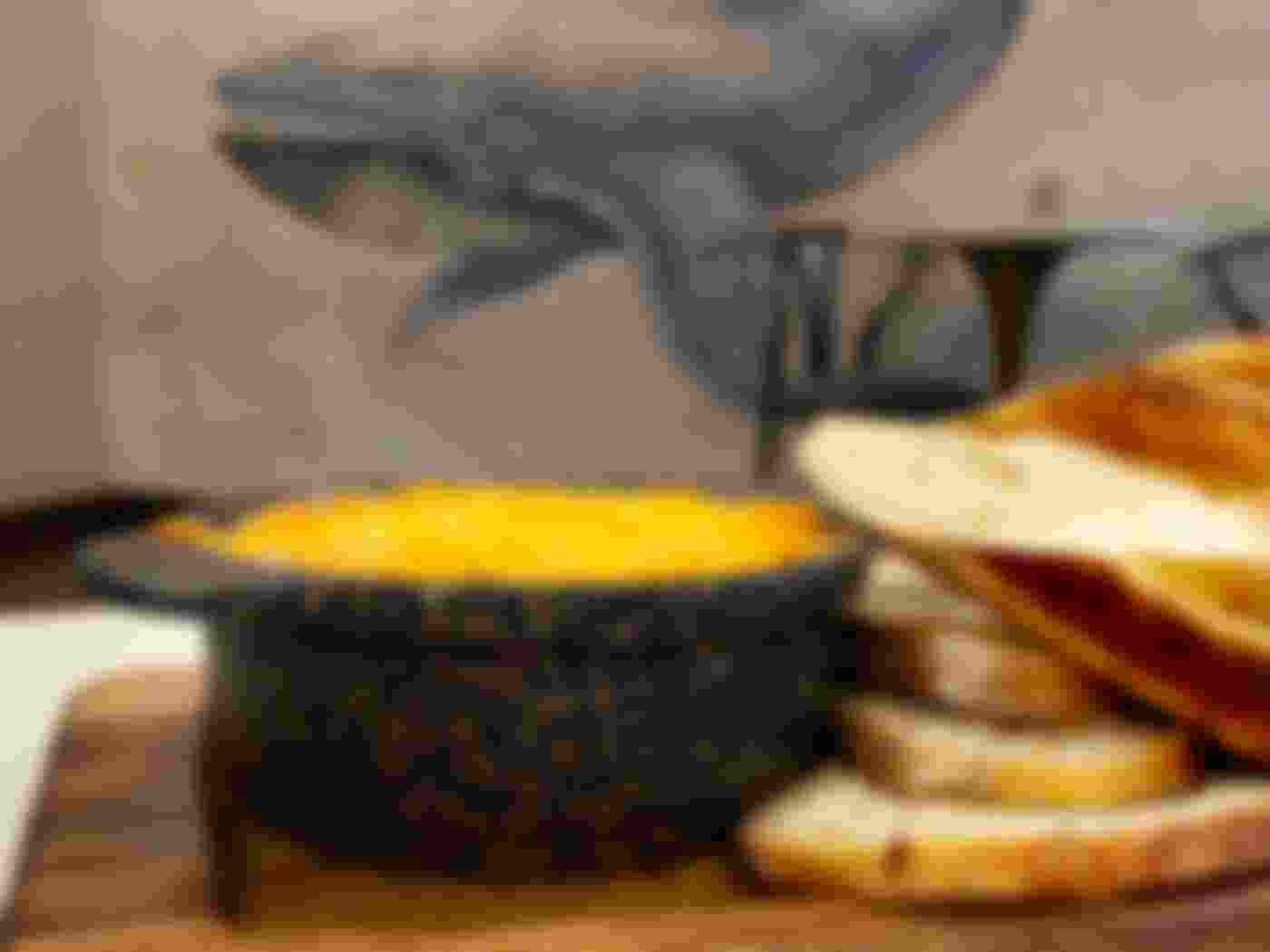bread with cheese sauce on wooden board with whale on wall in background